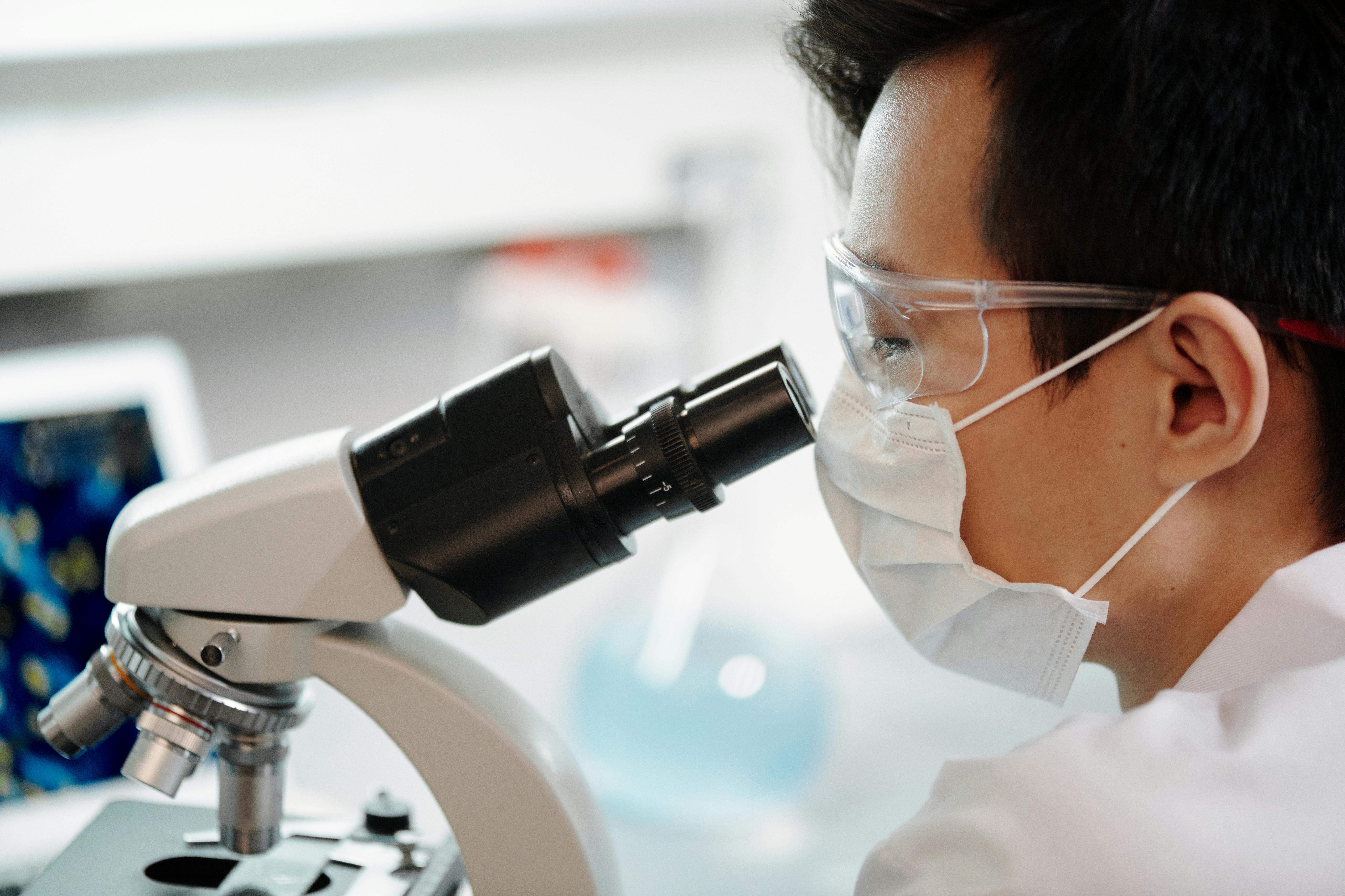 Scientist looking through microscope in laboratory setting